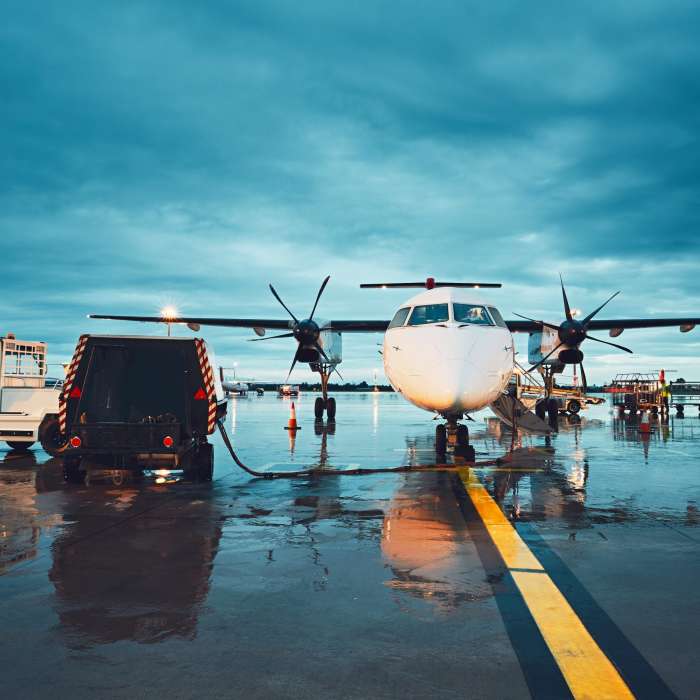 A busy airport in the rain. Preparation of the propeller airplane before flight.